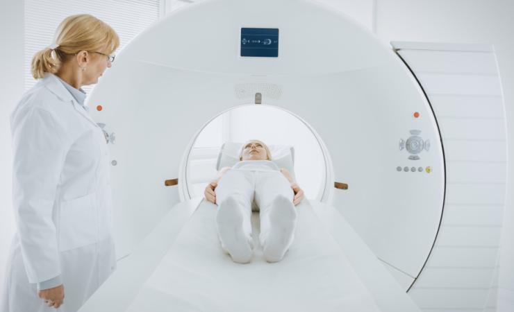 A woman undergoing a PET (positron emission tomography) scan, viewed from her feet. Image by Gorodenkoff via Shutterstock