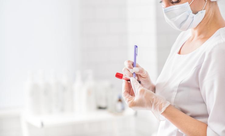 Woman writing on a blood test vial. Credits: lena Yakobchuk via Shutterstock