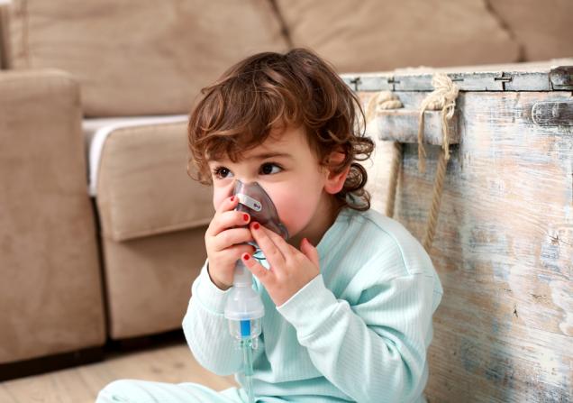 Child with inhalation mask. Image by Nikodash via Shutterstock.