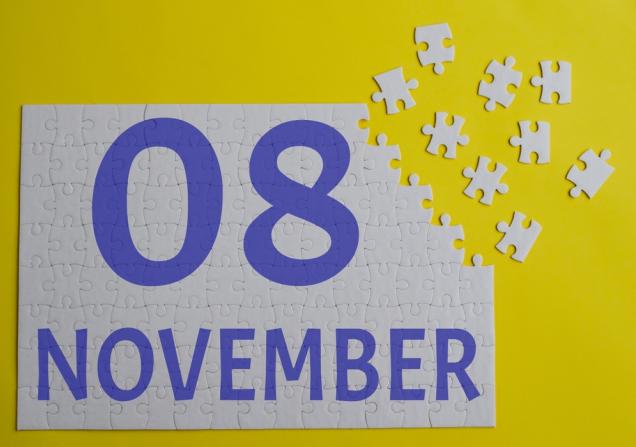 8 November written in purple on a white jigsaw puzzle, the top right corner of which is not completed. Image by Aritel via Shutterstock.