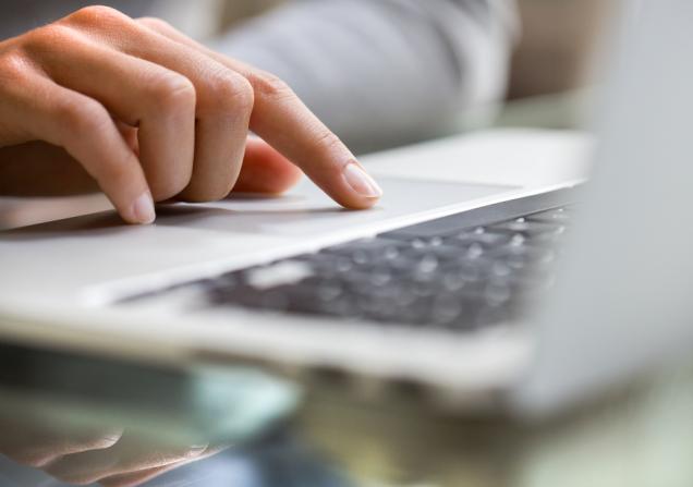 Close-up of a woman using a laptop. Image by LDprod via Shutterstock