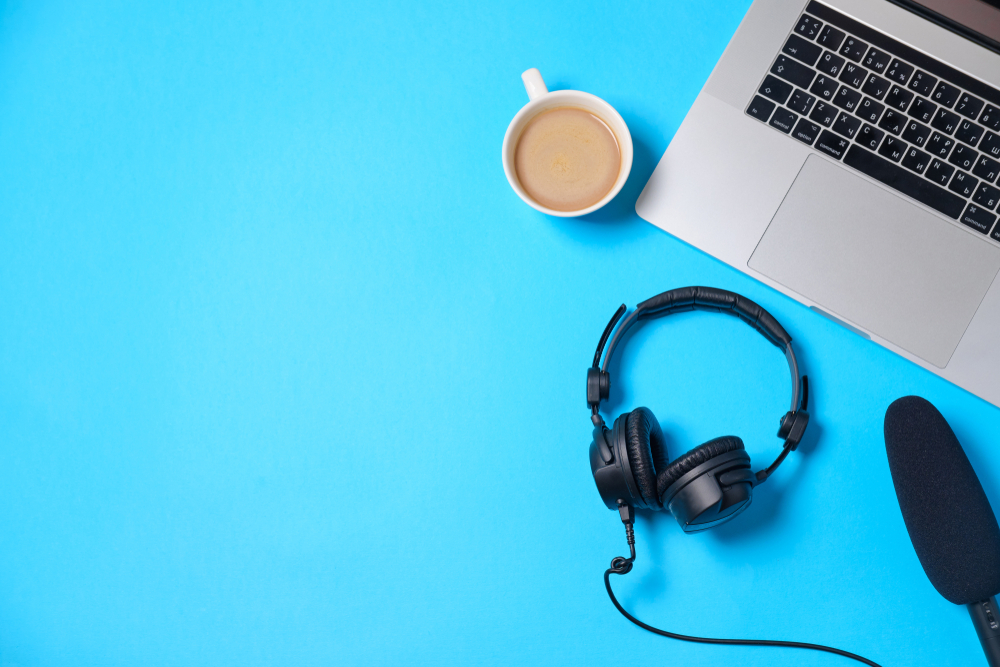 A laptop, headphones and coffee cup are viewed from above. Image by Boiarkina Marina via Shutterstock 