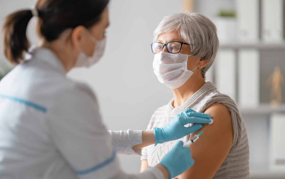 Woman preps vaccine by PIJITRA PHOMKHAM via Shutterstock