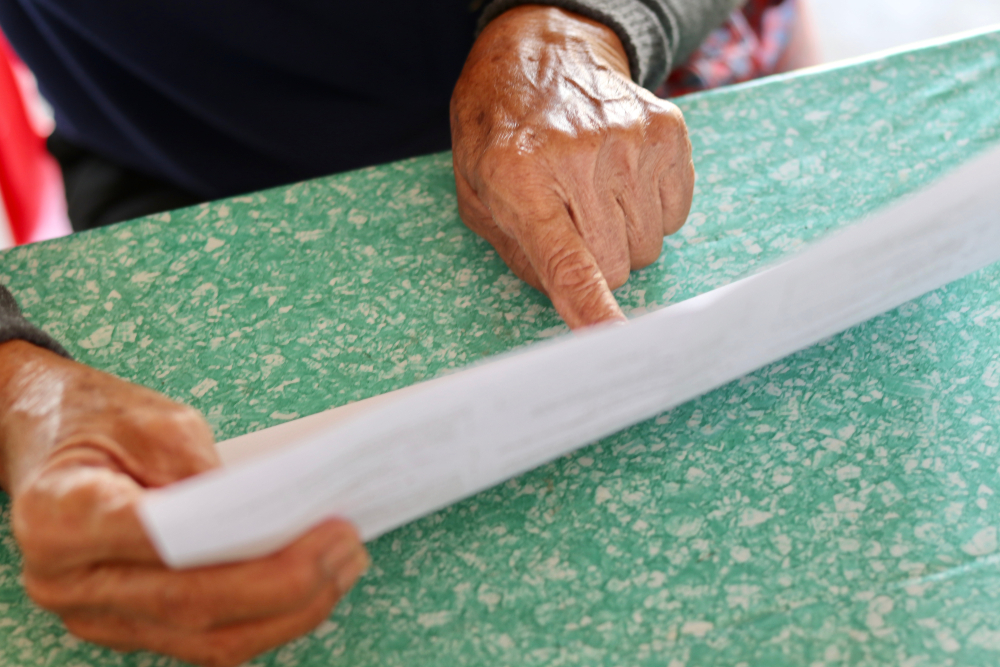 Elderly patient looks at a medicine leaflet. Image courtesy of kikpokemon via Shutterstock