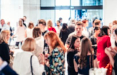 Image by Matej Kastelic via Shutterstock. Blurred image of business people at coffee break at conference meeting.