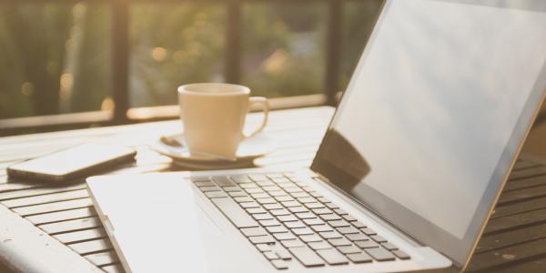 A laptop on a table outdoors. IHI call topics for health research and innovation projects are online. © TNShutter, Shutterstock