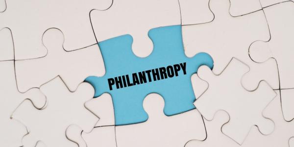 A white jigsaw with a missing piece - the word 'philanthropy' is written in the gap. Image by My Stockers via Shutterstock.
