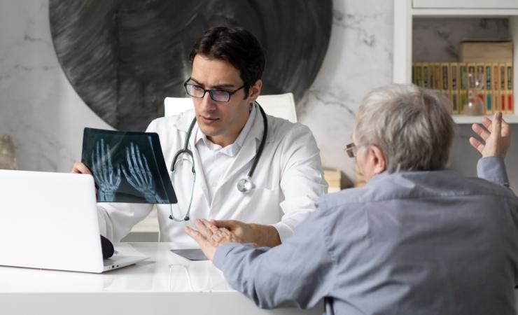 A doctor discussing an arthritis diagnosis with a patient. Image by Vitaliy Abbasov via Shutterstock.