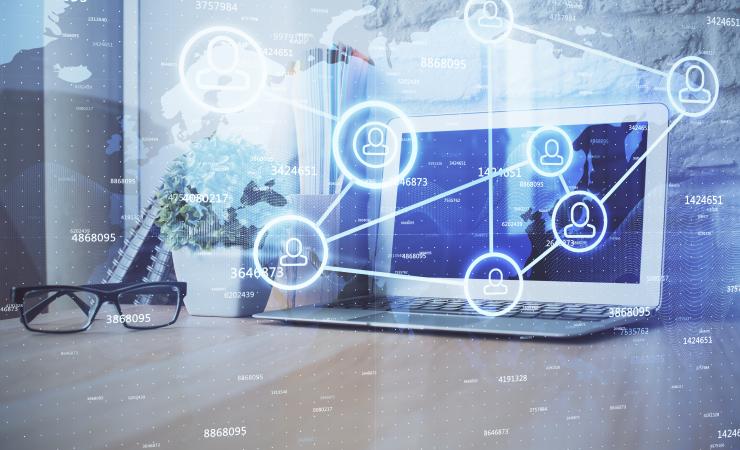 Computer on desktop with social network hologram.