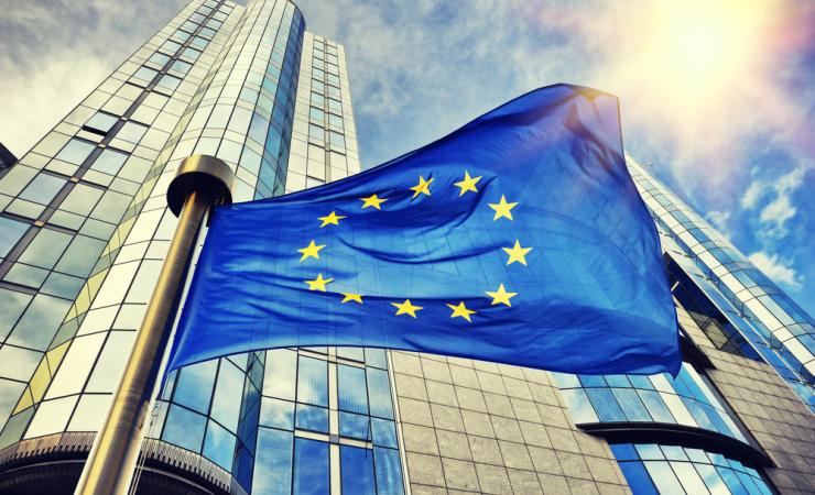 An EU flag flying outside the European Parliament in Brussels, Belgium. Image by symbiot via Shutterstock.