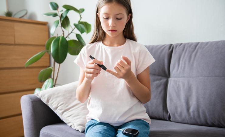 A child with type 1 diabetes checks her blood sugar level – we need new treatments.