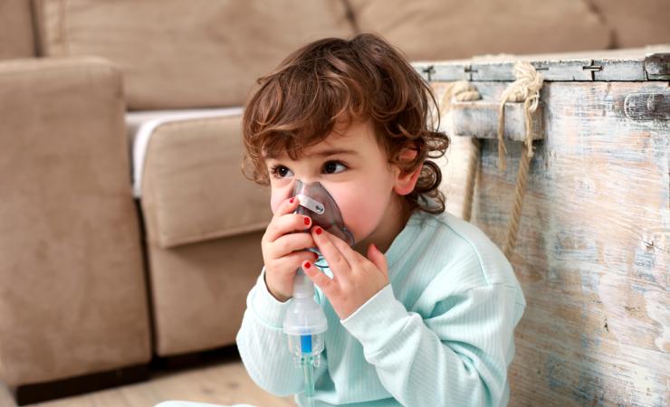 Child with inhalation mask. Image by Nikodash via Shutterstock. 