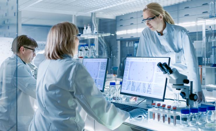 Scientists discussing research in a clinical laboratory. Image credit: Gorodenkoff 