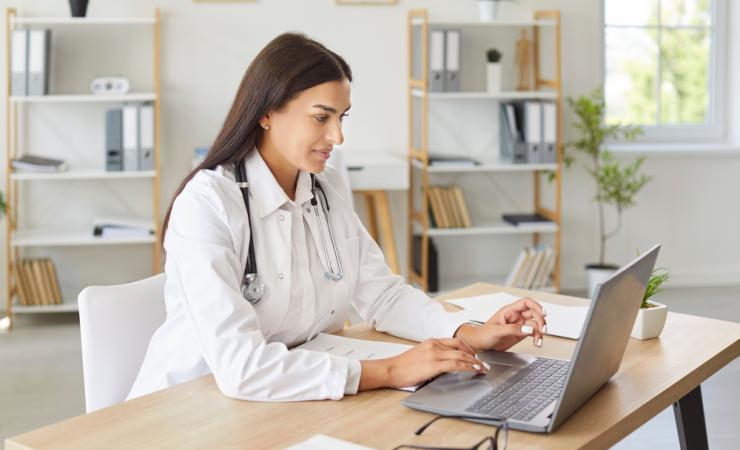 A doctor using a laptop. PATH will deliver AI tools to help improve cancer patient care.