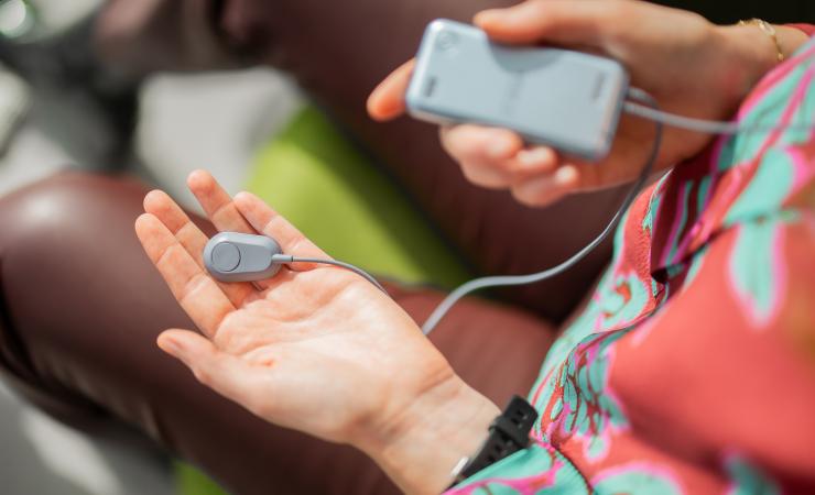 An image of the My Salvia wearable device from Salvia Bioelectronics being held in someone's hand. This device will be used as part of Hospital@Home. 