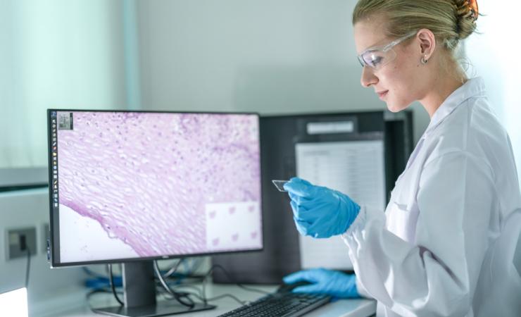 A pathologist examining a whole slide image, both in physical form and digitised form.