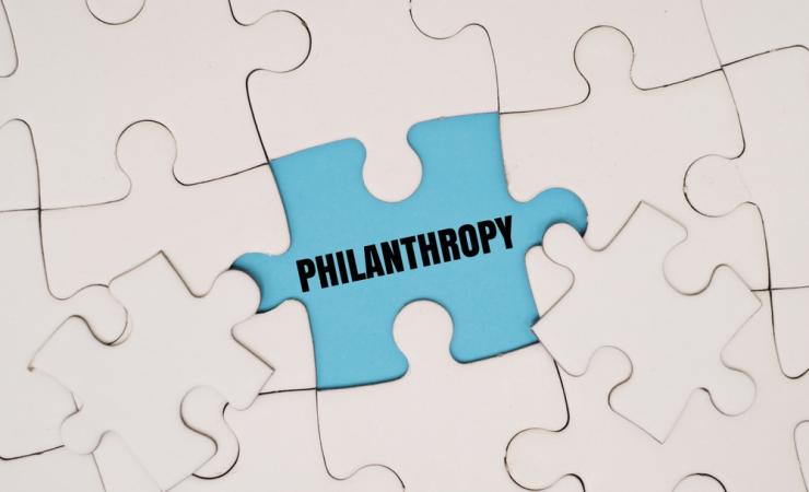 A white jigsaw with a missing piece - the word 'philanthropy' is written in the gap. Image by My Stockers via Shutterstock.