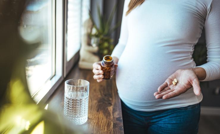 Pregnant woman using medication. Image by Dragana Gosic via Shutterstock. 