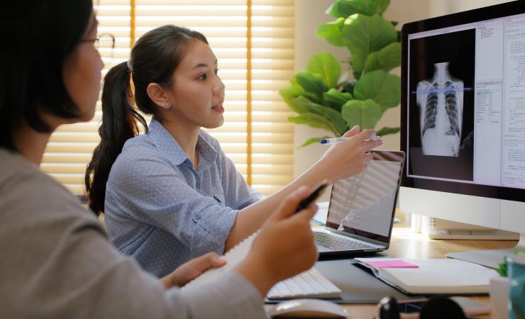 Researchers working with a computer scan. Image credit Chay_Tee via Shutterstock