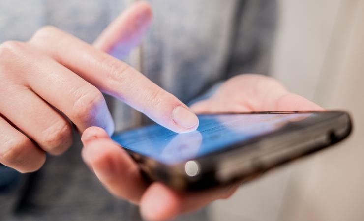 A close-up of a person using a smartphone. Image by Effective Stock Photos via Shutterstock.