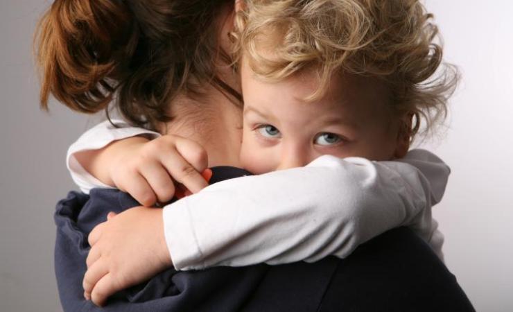 A parent holding a child. C4c is testing a European paediatric clinical trial network.