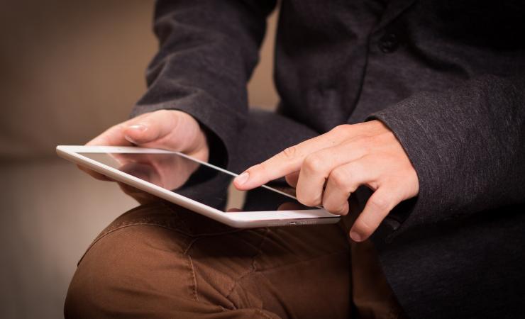 A man using a tablet. Image by Niek Verlaan via Pixabay.