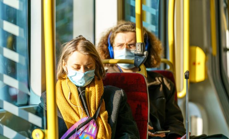 People on a tram wearing masks. Image by Orso via Shutterstock. 