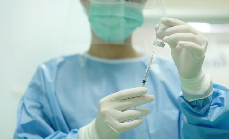 Woman preps vaccine by PIJITRA PHOMKHAM via Shutterstock