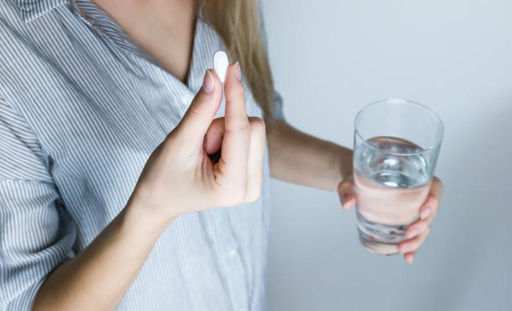 Woman takes a painkiller. Image courtesy of jeshootscom via Pexels