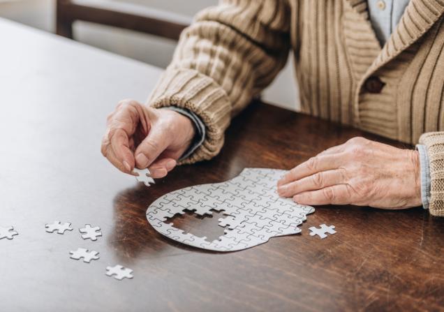 A man doing a jigsaw puzzle of a brain, symbolising Alzheimer's disease. © LightField Studios, Shutterstock