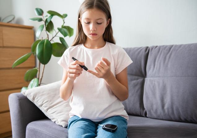 A child with type 1 diabetes checks her blood sugar level – we need new treatments.