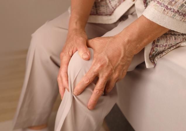 A woman holds her painful knee. We need research into osteoarthritis to develop new treatments. © VPLAB, Shutterstock
