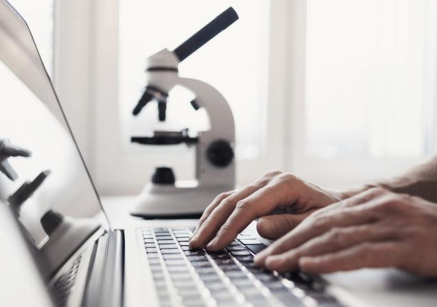 Person working at a computer with a laptop in the background. Image by Kite_rin via Shutterstock.
