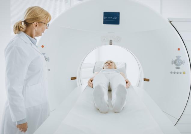 A woman undergoing a PET (positron emission tomography) scan, viewed from her feet. Image by Gorodenkoff via Shutterstock