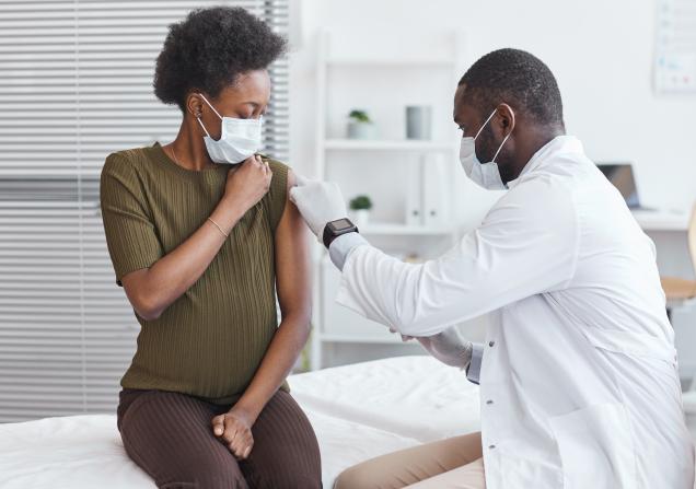 A pregnant woman receiving a vaccine. Image by Seventyfour via Adobe Stock.