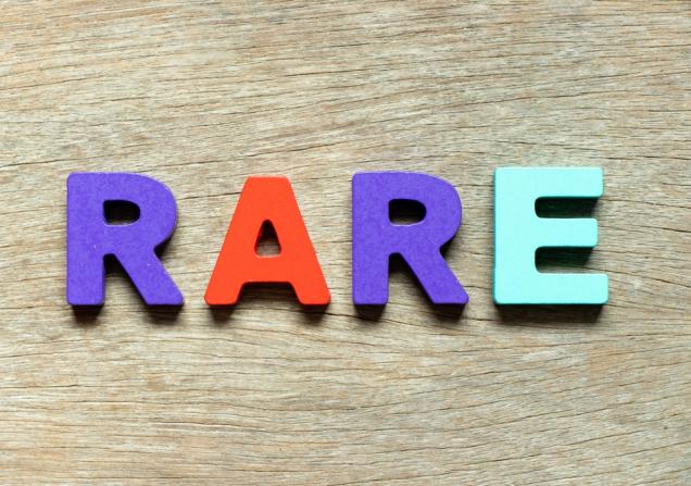The word RARE written in colourful blocks, lying on a wooden surface. Image by Bankrx via Shutterstock.