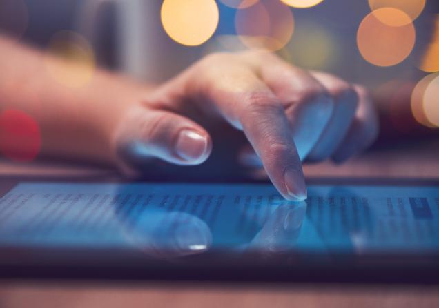 A close-up of a woman's hand scrolling on a tablet. Image by Bits And Splits via Shutterstock.