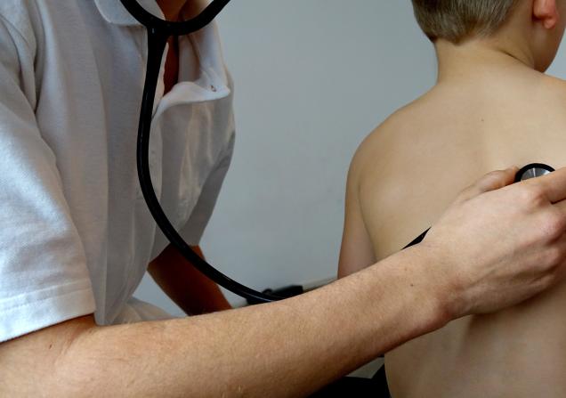 A doctor listens to a child's lungs via a stethoscope. Image by Semevent via Pixabay