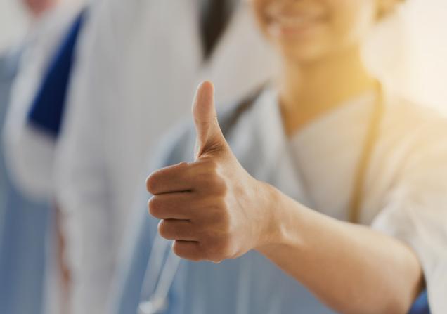 A healthcare worker gives a thumbs up sign. Image by Syda Productions via Shutterstock