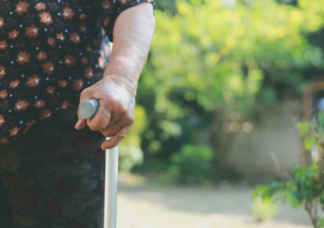 Close-up of a senior woman with a walking stick. Image by KoOlyphoto via Shutterstock.