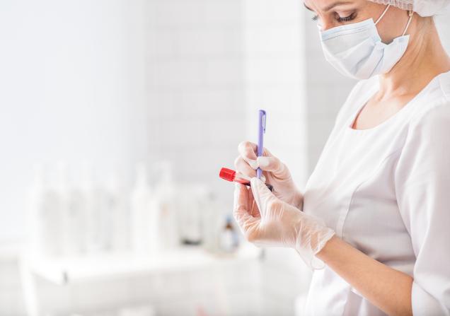 Woman writing on a blood test vial. Credits: lena Yakobchuk via Shutterstock