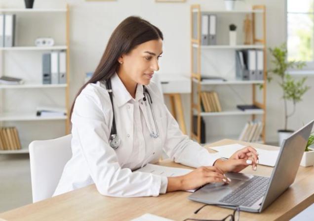 A doctor using a laptop. PATH will deliver AI tools to help improve cancer patient care.