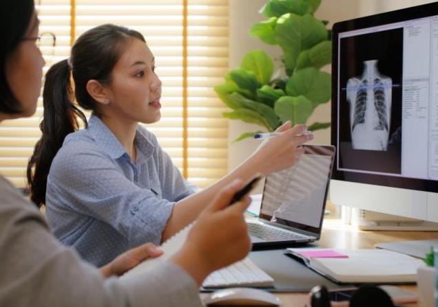 Researchers working with a computer scan. Image credit Chay_Tee via Shutterstock