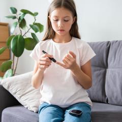 A child with type 1 diabetes checks her blood sugar level – we need new treatments.