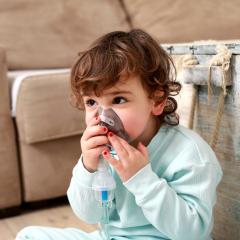 Child with inhalation mask. Image by Nikodash via Shutterstock. 