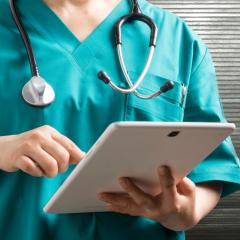 A doctor checks a patient's electronic health record, a source of real-world evidence and data