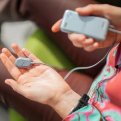 An image of the My Salvia wearable device from Salvia Bioelectronics being held in someone's hand. This device will be used as part of Hospital@Home. 