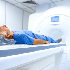 An elderly man who is about to have an MRI scan. He has white hair and a beard and is wearing what looks like blue, hospital issue pyjamas.  Image by Aleksandar Malivuk via Shutterstock