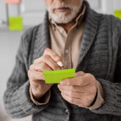 A man with memory problems due to early stage Alzheimer’s disease makes a note.