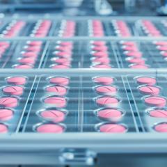Pink pills rolling off the production line. Image by IM Imagery via Shutterstock.